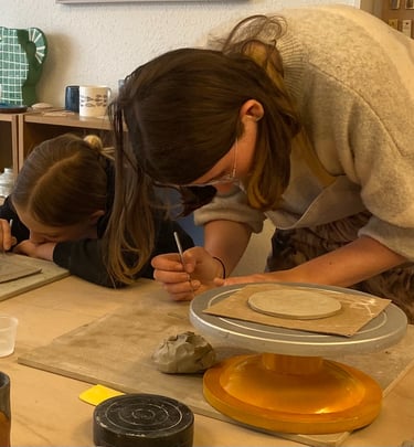 Two young girls making slab built mugs at a pottery class in Bristol