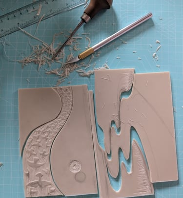 a jigsaw linocut print being assembled with printmaking tools on desk