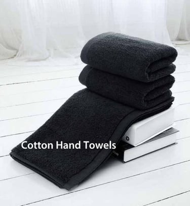 a stack of Cotton hand towels on a white floor