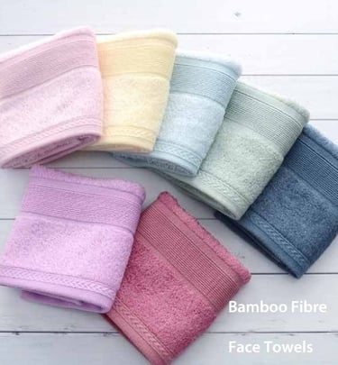 a variety of colored bamboo fibre face towels on a white table