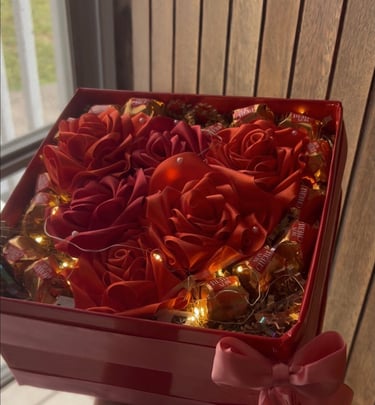 a person holding a red box with roses in it