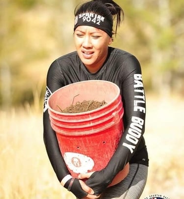 Female WOR battle buddy in long sleeve during Spartan bucket carry