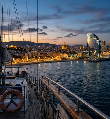 Barcelona illuminated skyline seen from sailing yacht at dusk with W Hotel and coastline