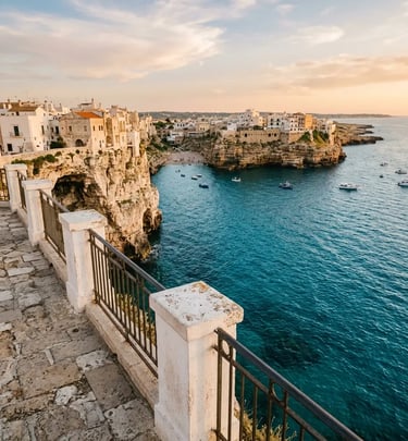 Clifftop terrace viewpoint in Polignano a Mare overlooking turquoise Adriatic Sea at sunset