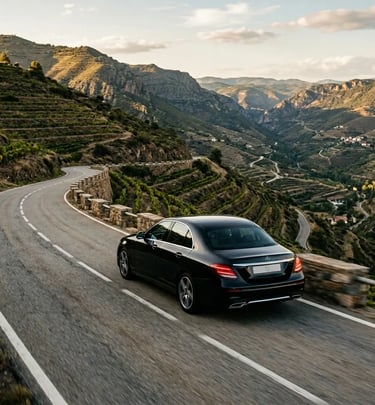 Private luxury sedan on a winding mountain road through Priorat vineyards