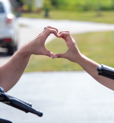 a man and woman making a heart shape with their hands