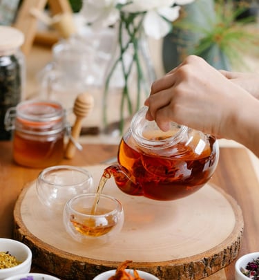 a person pouring tea into a cup