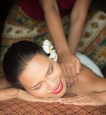 A woman smiling while being massaged 
