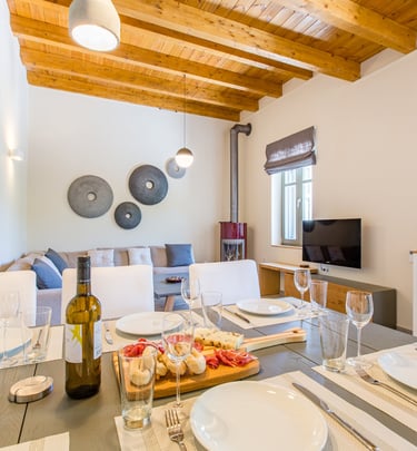 Rustic-chic living and dining room with wooden ceiling beams at Villa Skyphos
