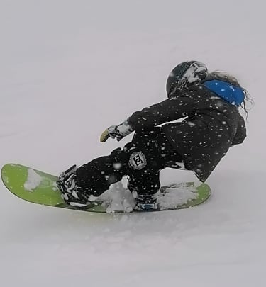 un bambino esegue un tail press con lo snowboard