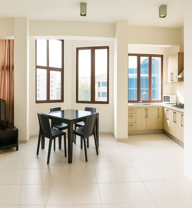 Modern open plan apartment with a dining set, kitchen cabinets, and bright windows.
