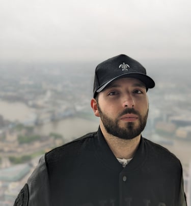 a man in a black jacket wearing a classic tortuga island black cap