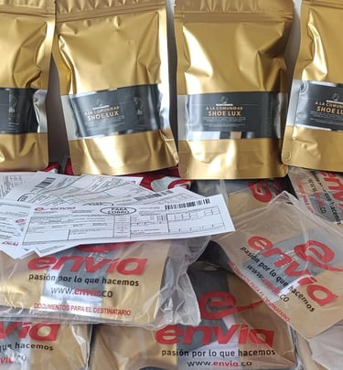 Gold packaging bags for Shoe Lux footwear stacked with Envia shipping envelopes and delivery.
