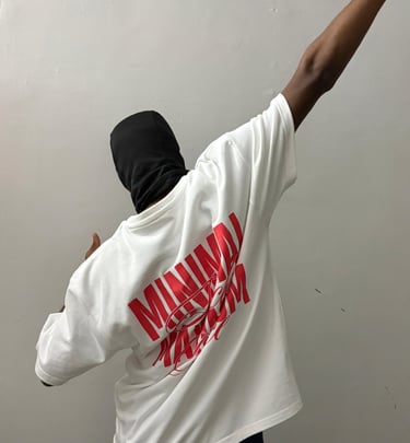 A person in a black balaclava wears an oversized white t-shirt with red streetwear graphics.