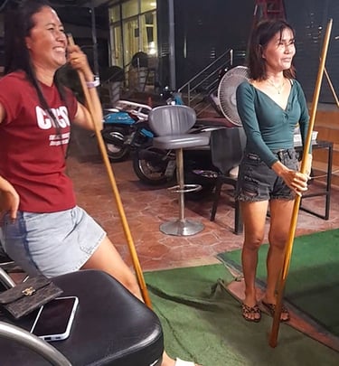 Thai women smiling at pool table at bar near Soi 94 in Hua Hin