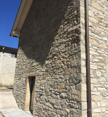 a stone wall with a small window in the middle of it
