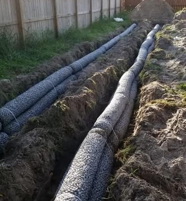 2 trenches dug with septic drainage pipe laid in it