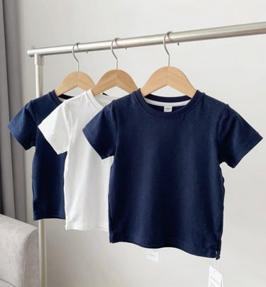 A neatly arranged display of various t-shirts in vivid colors on sleek hangers