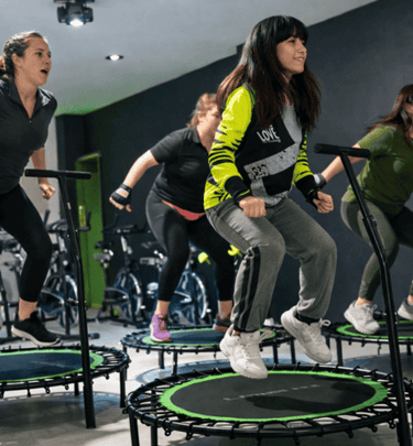 Un grupo realizando un entrenamiento cardiovascular en una clase de jumping.