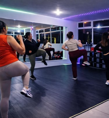 Grupo de mujeres en una clase de Tae Bo de alta intensidad en un gimnasio moderno con luces neón