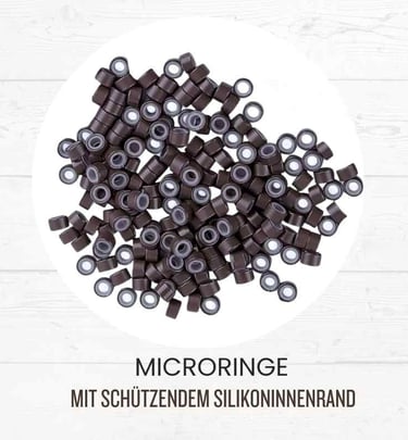 Dark brown silicone lined micro rings for hair extensions on a white wood background.