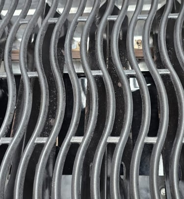 Close-up of professionally cleaned BBQ grill grates showing spotless finish