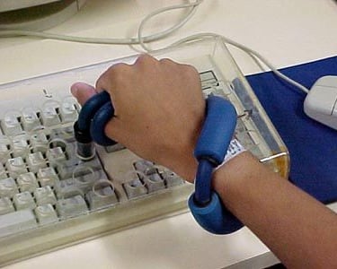 a mão de uma pessoa segurando uma tesoura e um mouse de computador