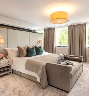 Cozy bedroom with a bed, bedside table, chaise lounge, featuring neutral tones, dark green accentst