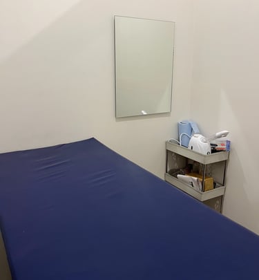 A cozy small room featuring a blue bed and a mirror, creating a serene and inviting atmosphere