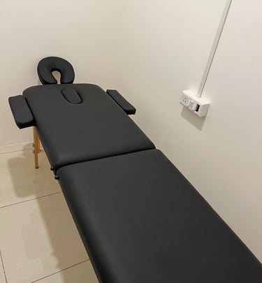 A massage table in a peaceful room with a bright white wall, designed for comfort and relaxation during massage therapy
