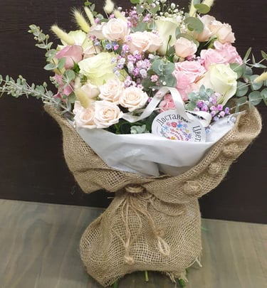Hand-tied pastel floral arrangement in rustic burlap wrap