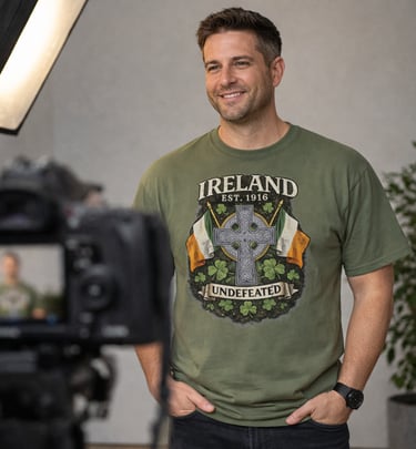 A smiling man wearing an olive green Ireland Celtic cross t-shirt on a professional video set.