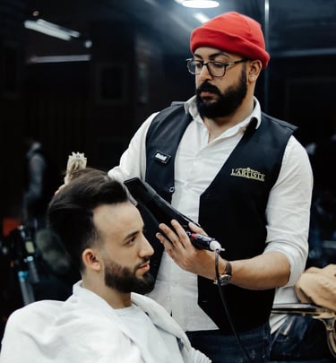 a man in a red hat is getting his hair styled