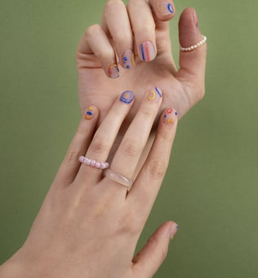 les mains d'une femme avec des bagues et du vernis sur les ongles