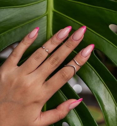 la main d'une femme avec des bagues et du vernis sur les ongles