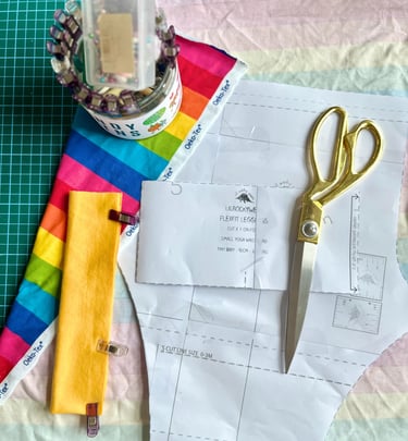 a pair of scissors with fabric and a lilrockywear sewing pattern