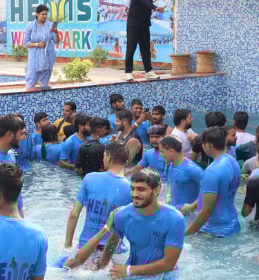 a man in a blue shirt is standing in a pool