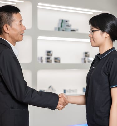 Professional business handshake between a male executive and female colleague in a modern office.