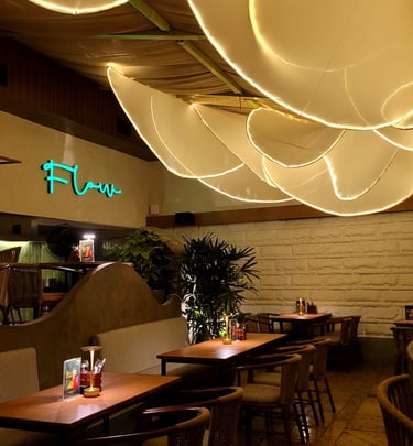 Modern restaurant interior with unique overhead petal lighting and cozy wooden tables.