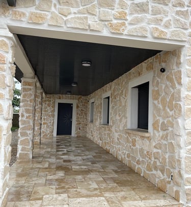 a stone building with a black door and a black door