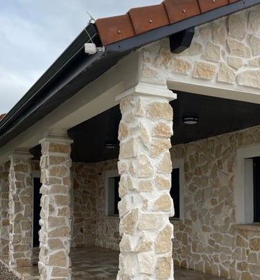 a house with a stone wall and a brick wall