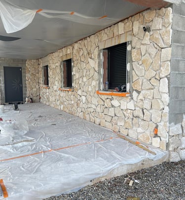 a house being built into a house with a large stone wall