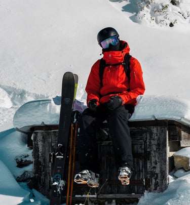 Baptiste Rouge qui se tient assis sur une petite maison alpine