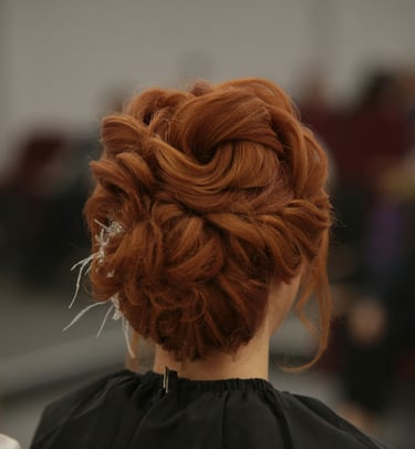 Recogido nupcial elegante en una mujer pelirroja con un moño trenzado intrincado