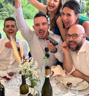 a group of people sitting at a table with wine glasses and wine bottles