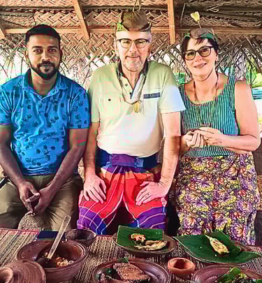Tourists wearing Sri Lankan traditional attire during a cultural experience with their driver.