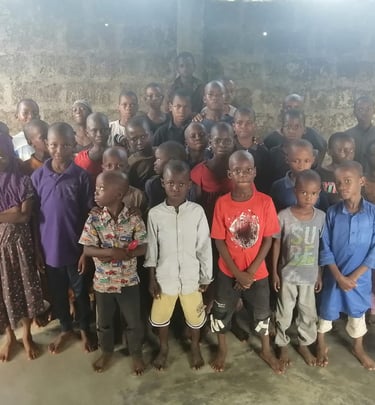 a group of children and adults posing for a group photo west africa