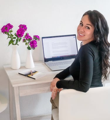 A professional writer sitting at their desk and smiling