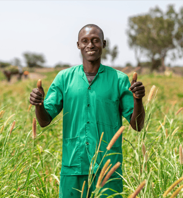 a man in a green shirt and green pants standing in a field
