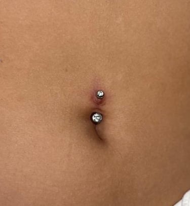 a woman with a piercing on her stomach